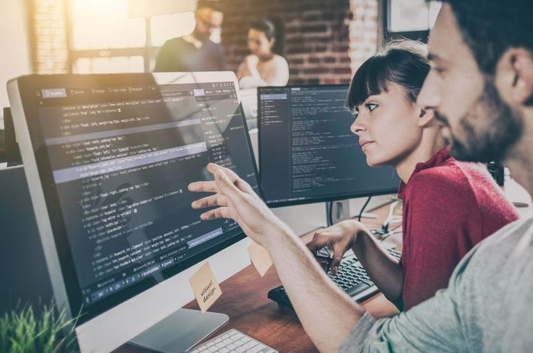 Diferentes personas trabajando con varios equipos